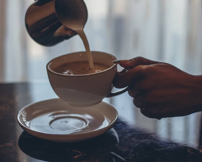 Milk being poured into a cup of kopi luwak coffee